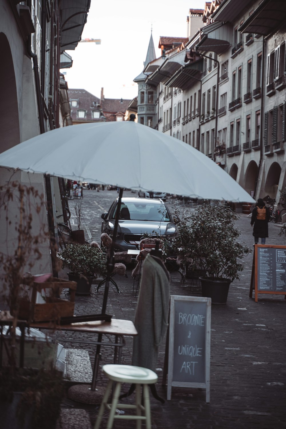 a white umbrella sitting on the side of a road