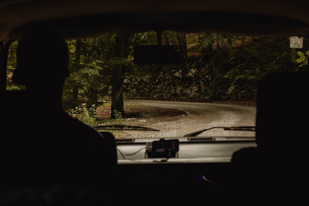 a car driving down a forest road at night