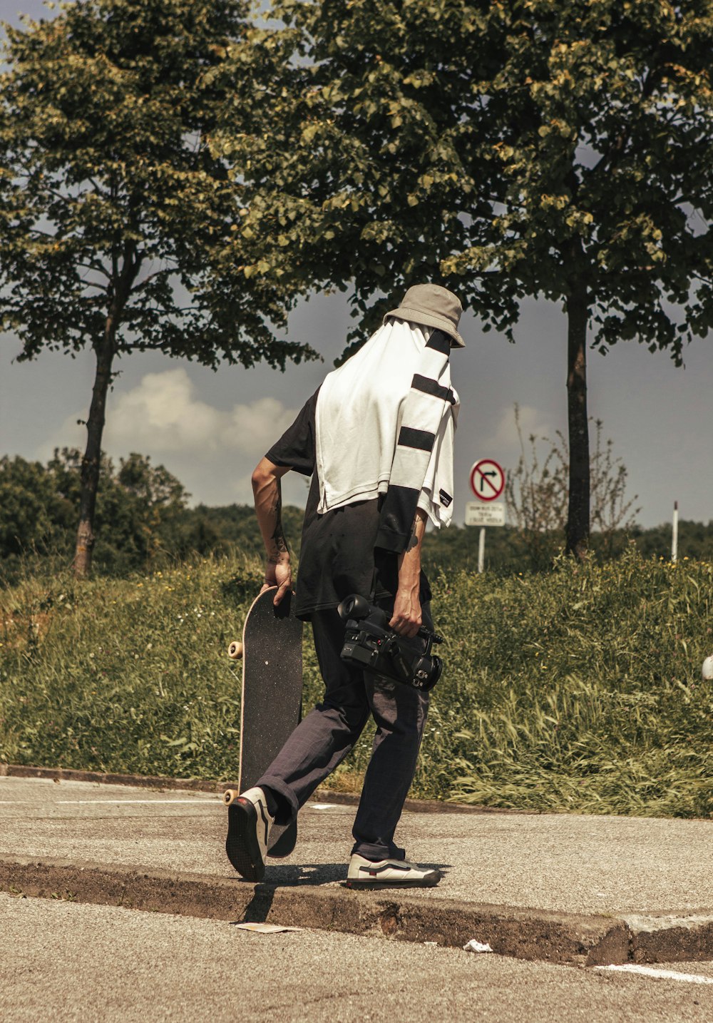 a man with a skateboard is walking down the street