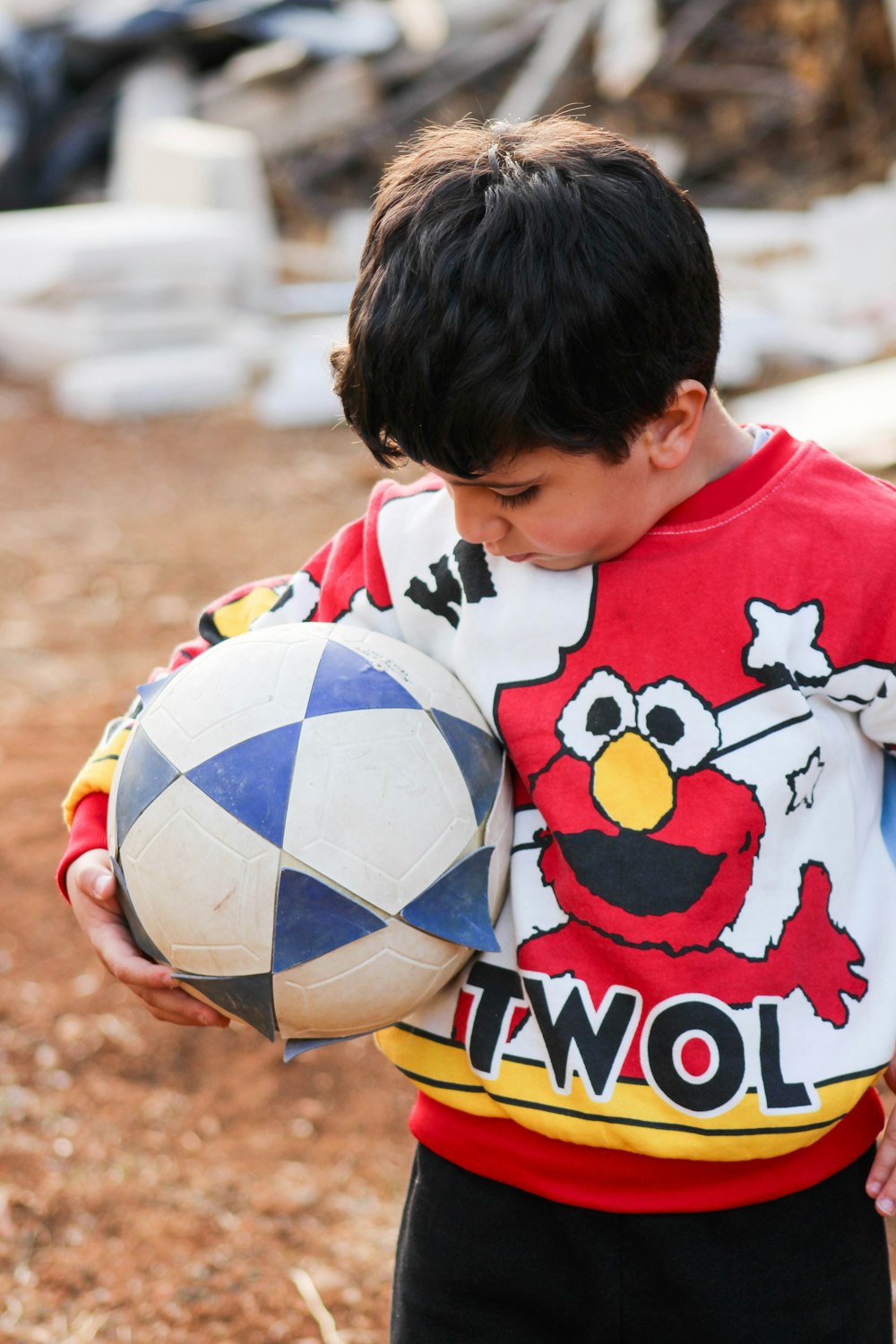a young boy holding a soccer ball in his hands