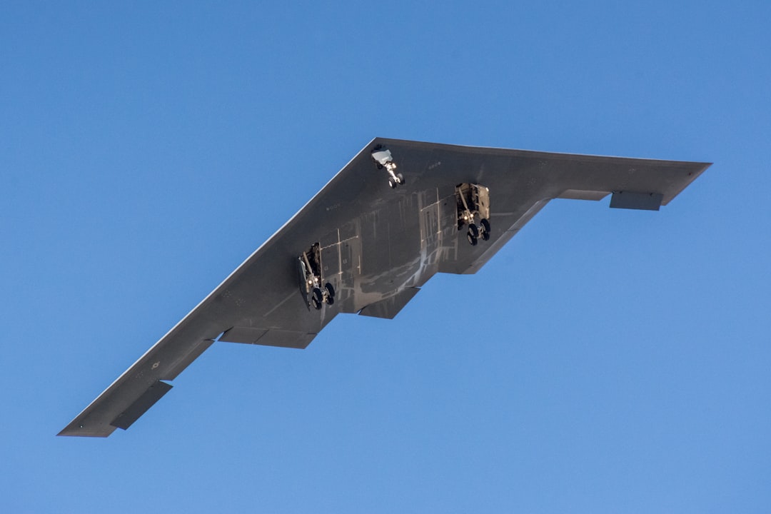 a large airplane flying through a blue sky, Northrop Grumman B-2 Spirit