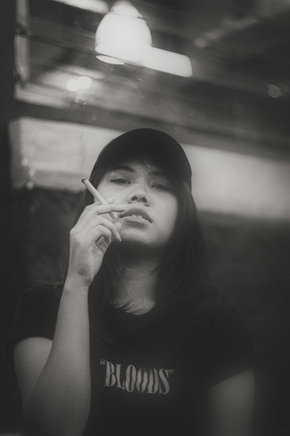 a woman smoking a cigarette in a black and white photo