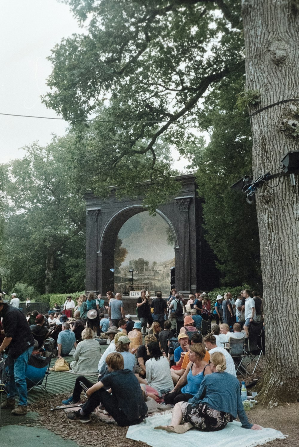 a large group of people sitting around a tree