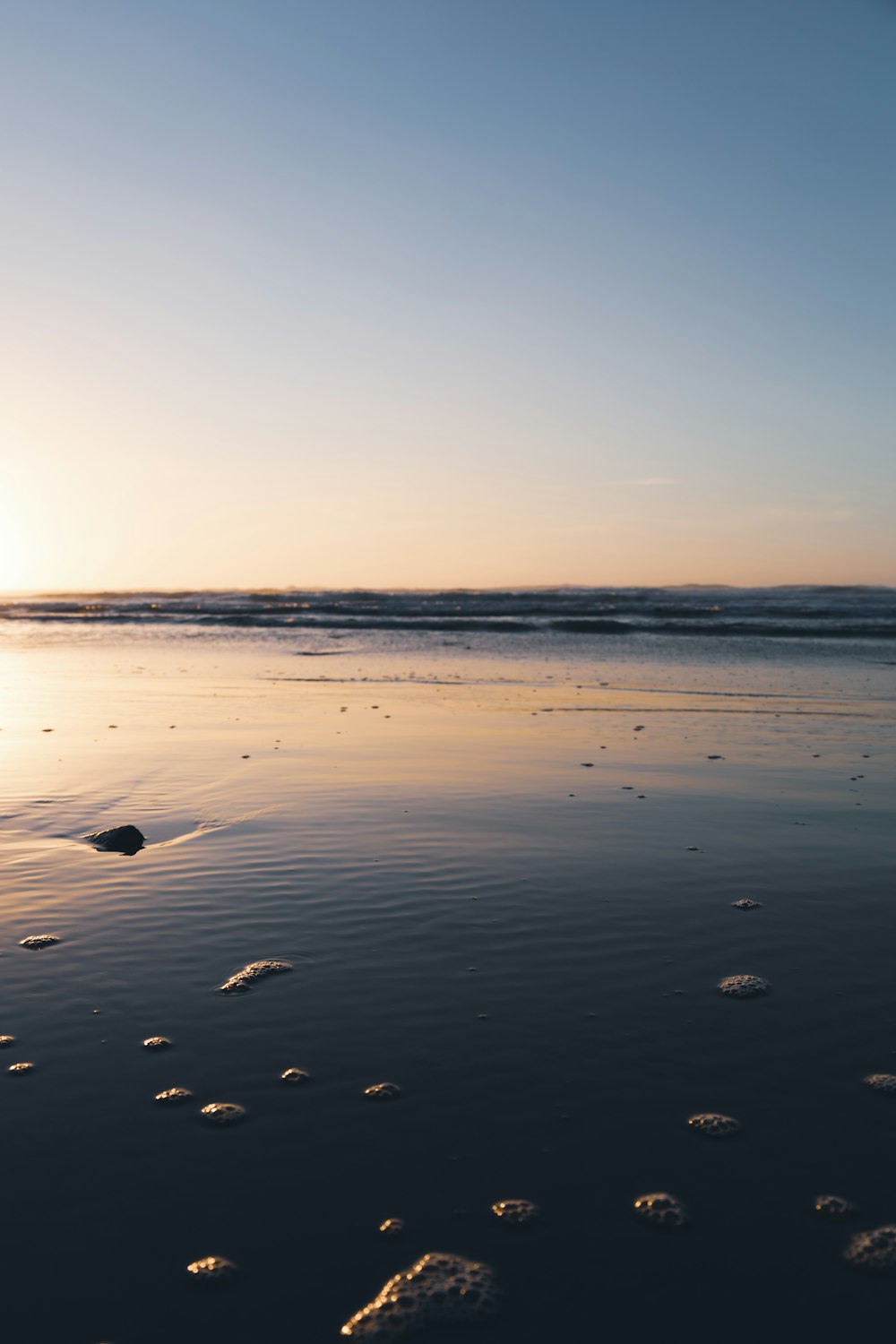 a person walking on a beach with a surfboard