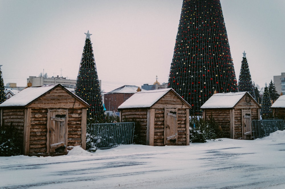 a row of wooden buildings with a christmas tree in the background