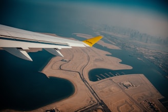 the wing of an airplane flying over a large body of water