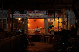a man standing outside of a store at night