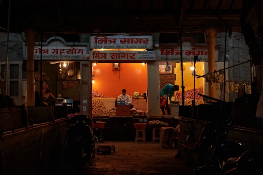 a man standing outside of a store at night