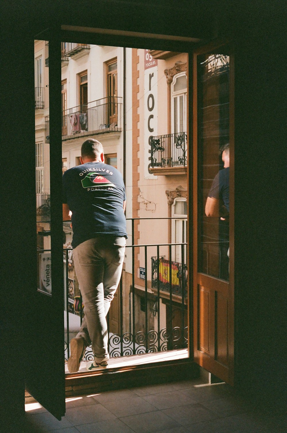 a man walking out of a doorway onto a balcony