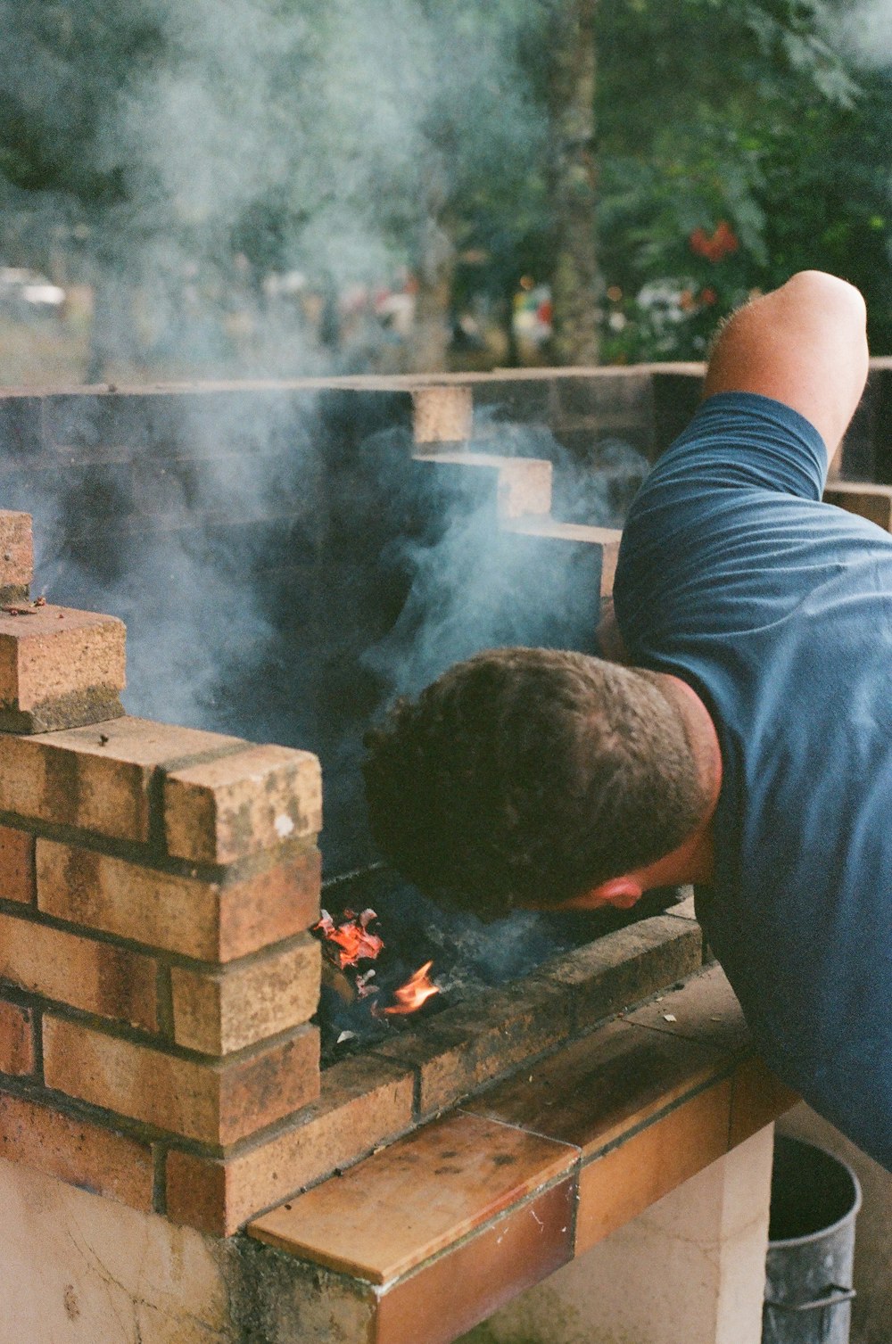 a man is cooking on a brick grill