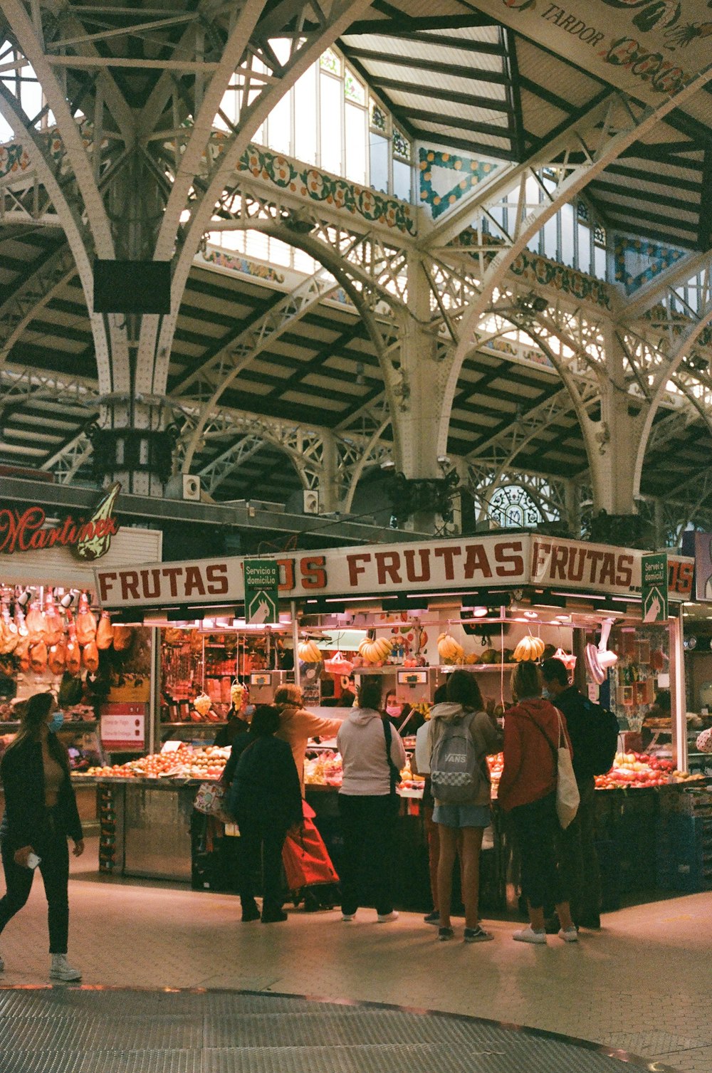 a group of people standing in front of a fruit stand