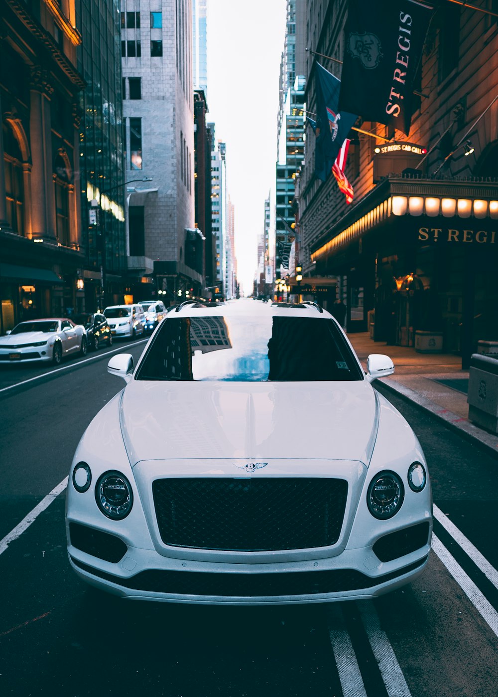 a white car is parked in the middle of the street