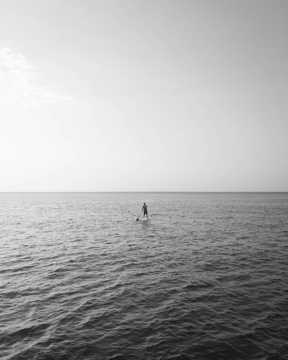 a person standing on a surfboard in the middle of the ocean