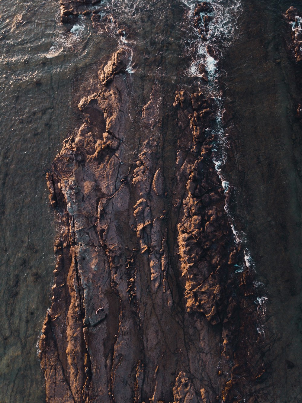 an aerial view of the ocean and cliffs