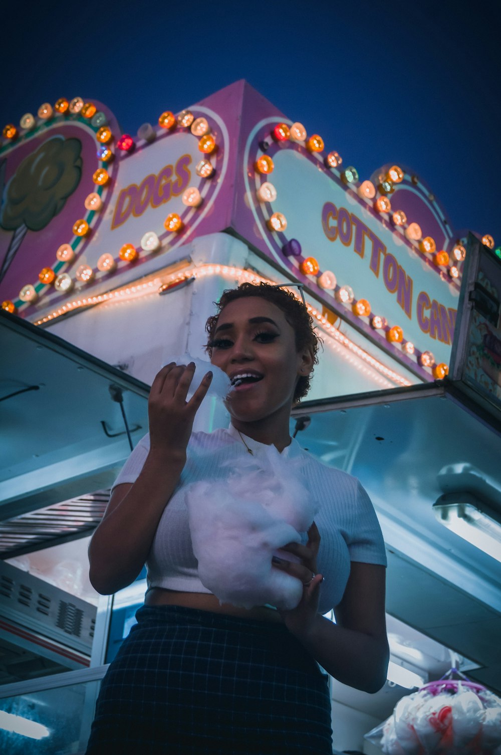 a woman standing in front of a carnival ride