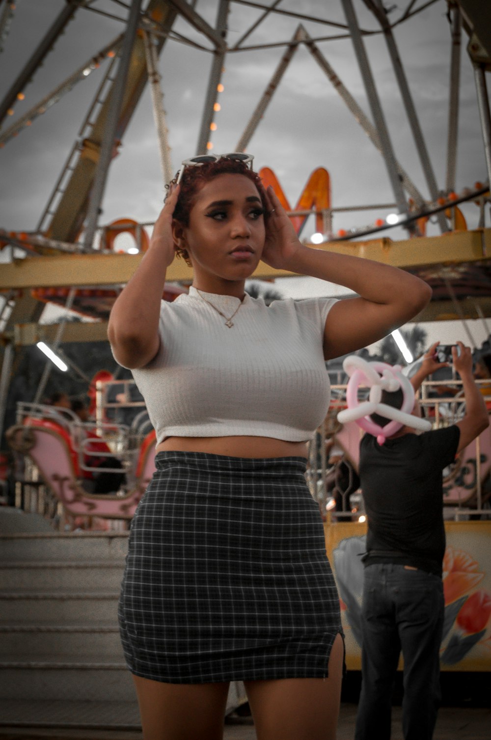 a woman standing in front of a carnival ride