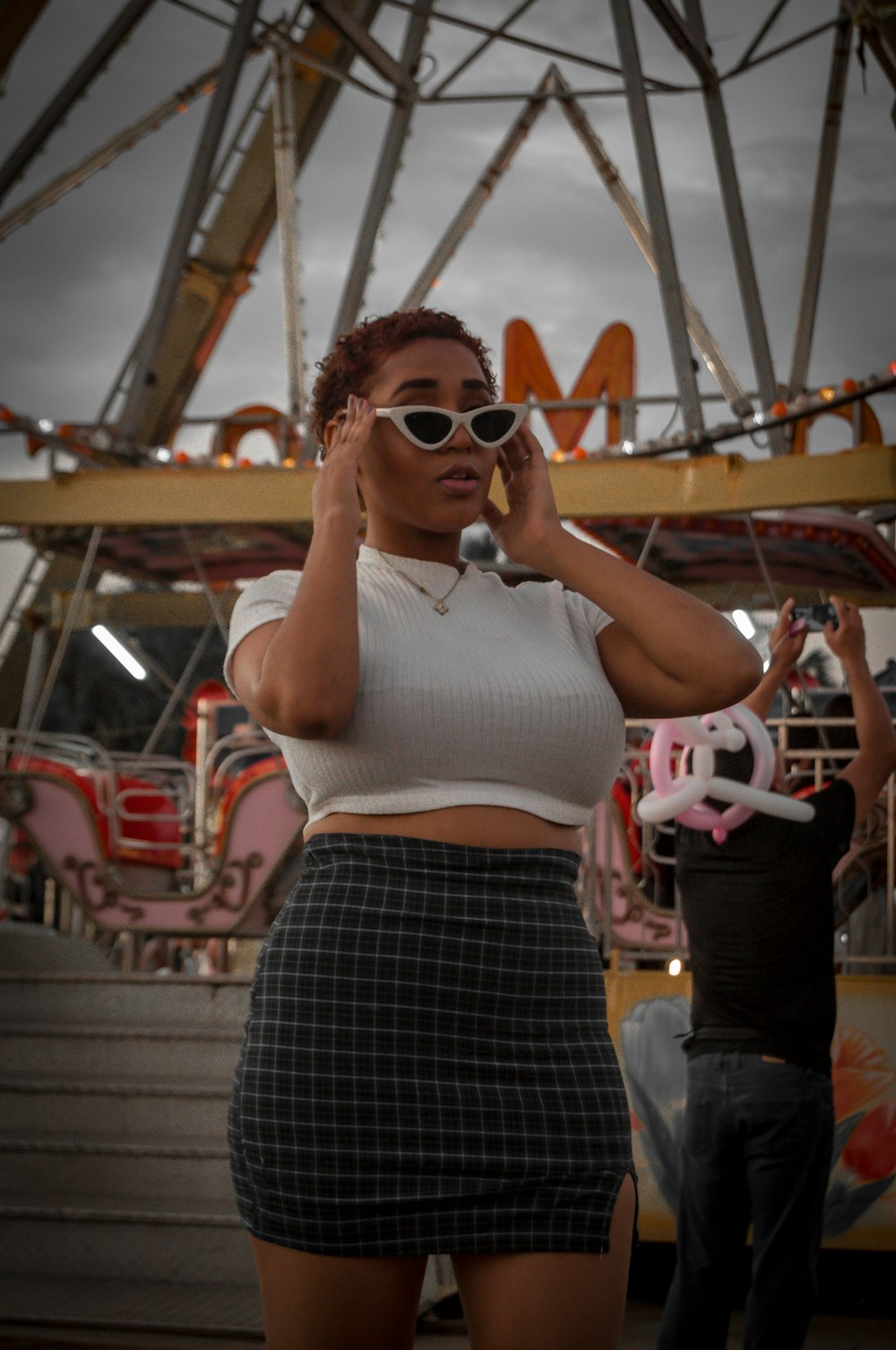 a woman standing in front of a carnival ride