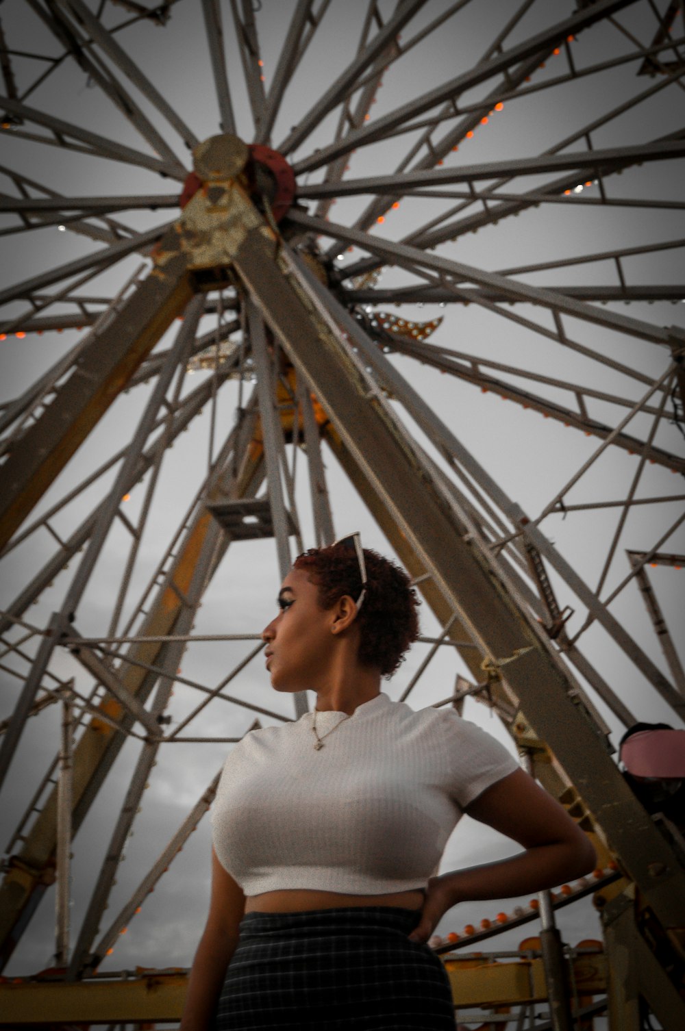 a woman standing in front of a ferris wheel