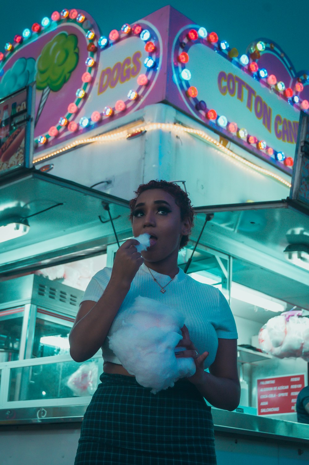 a woman standing in front of a carnival booth