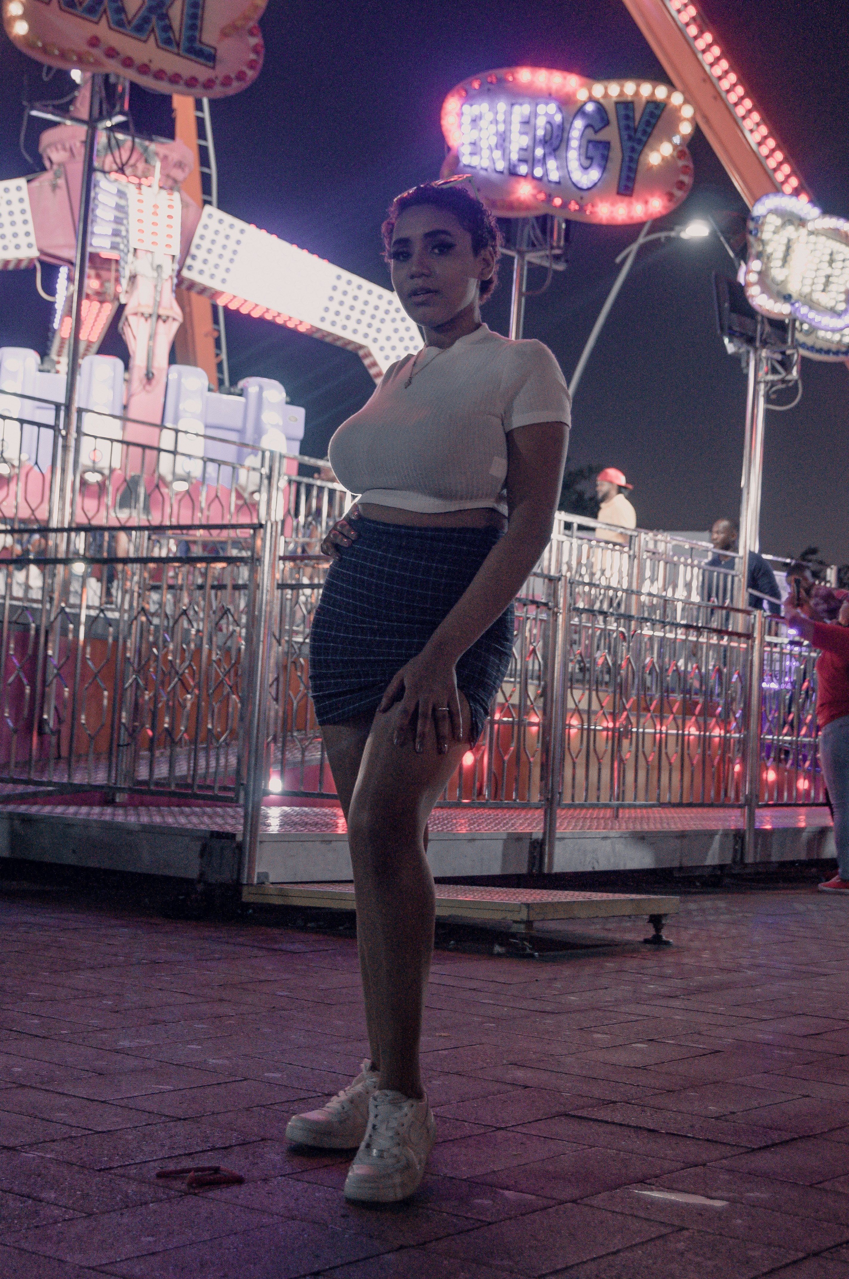 a woman standing in front of a carnival ride