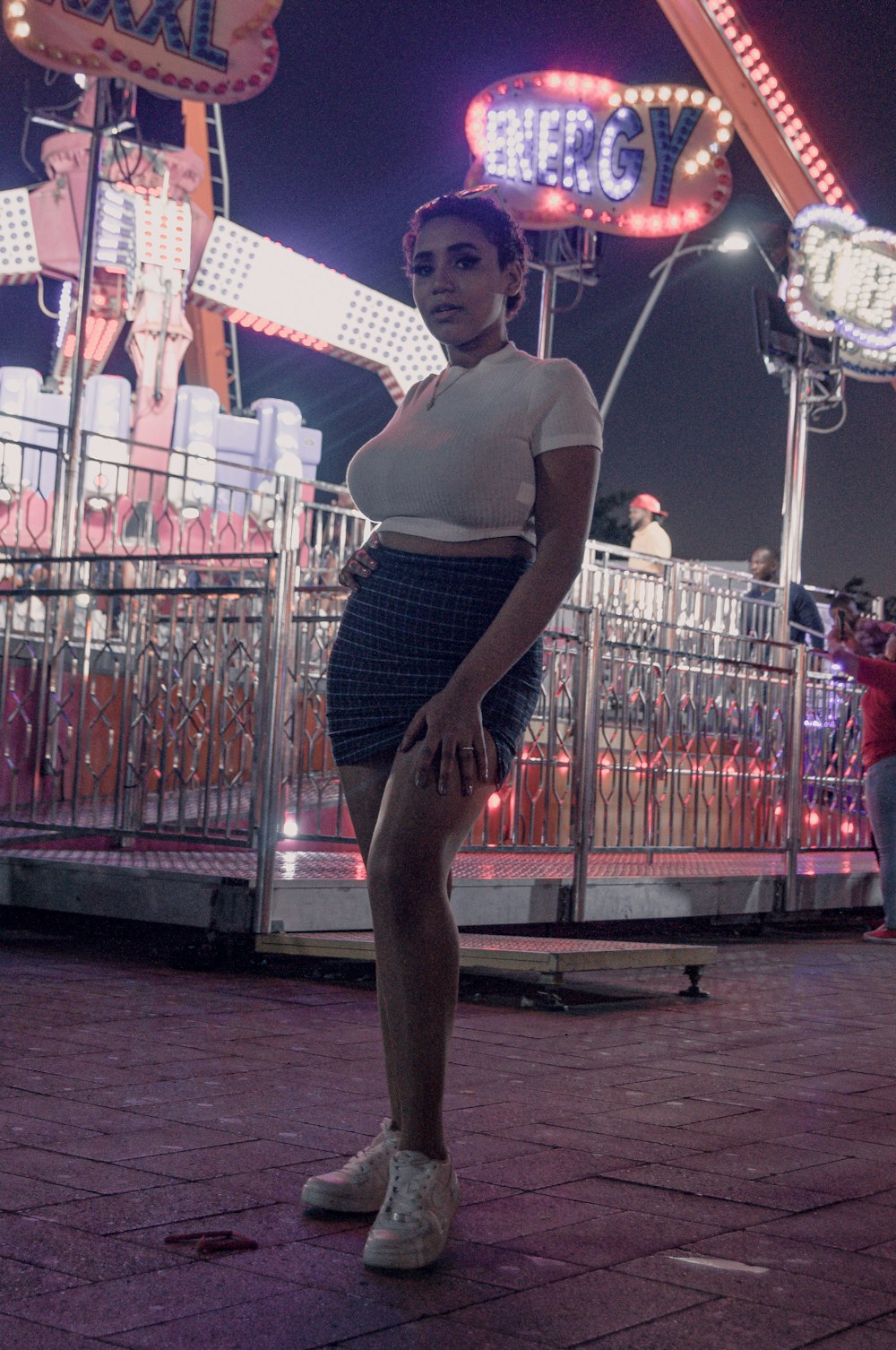 a woman standing in front of a carnival ride