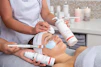 a woman getting a facial mask on her face