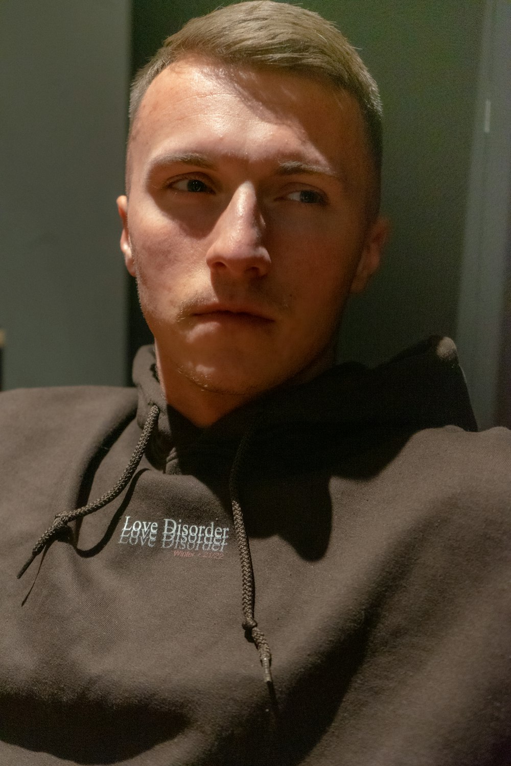 a man in a black hoodie looking at the camera