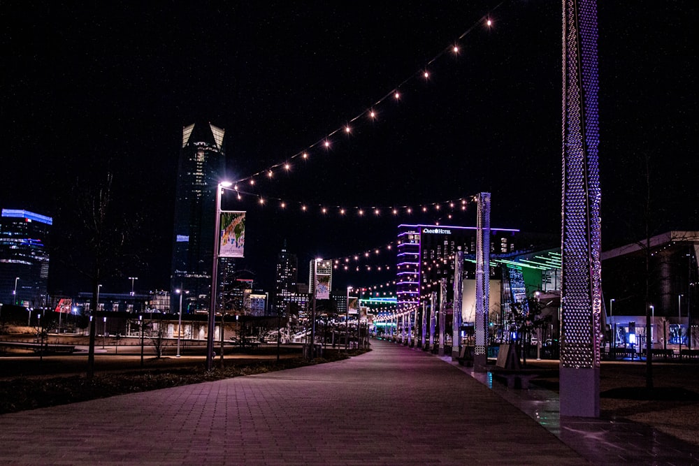 a walkway with lights strung over it at night