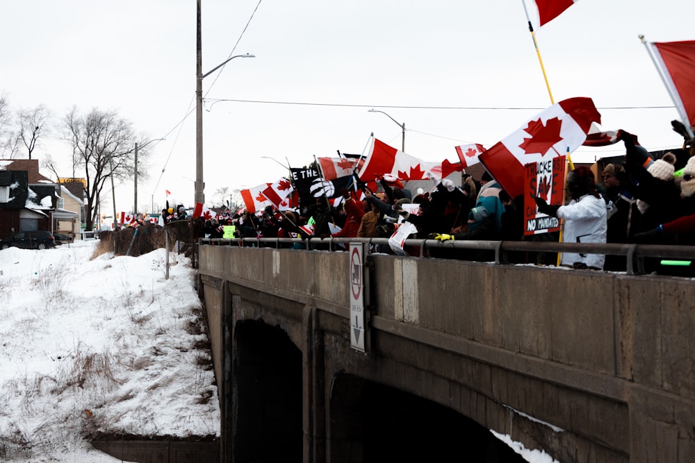 a crowd of people standing on top of a bridge