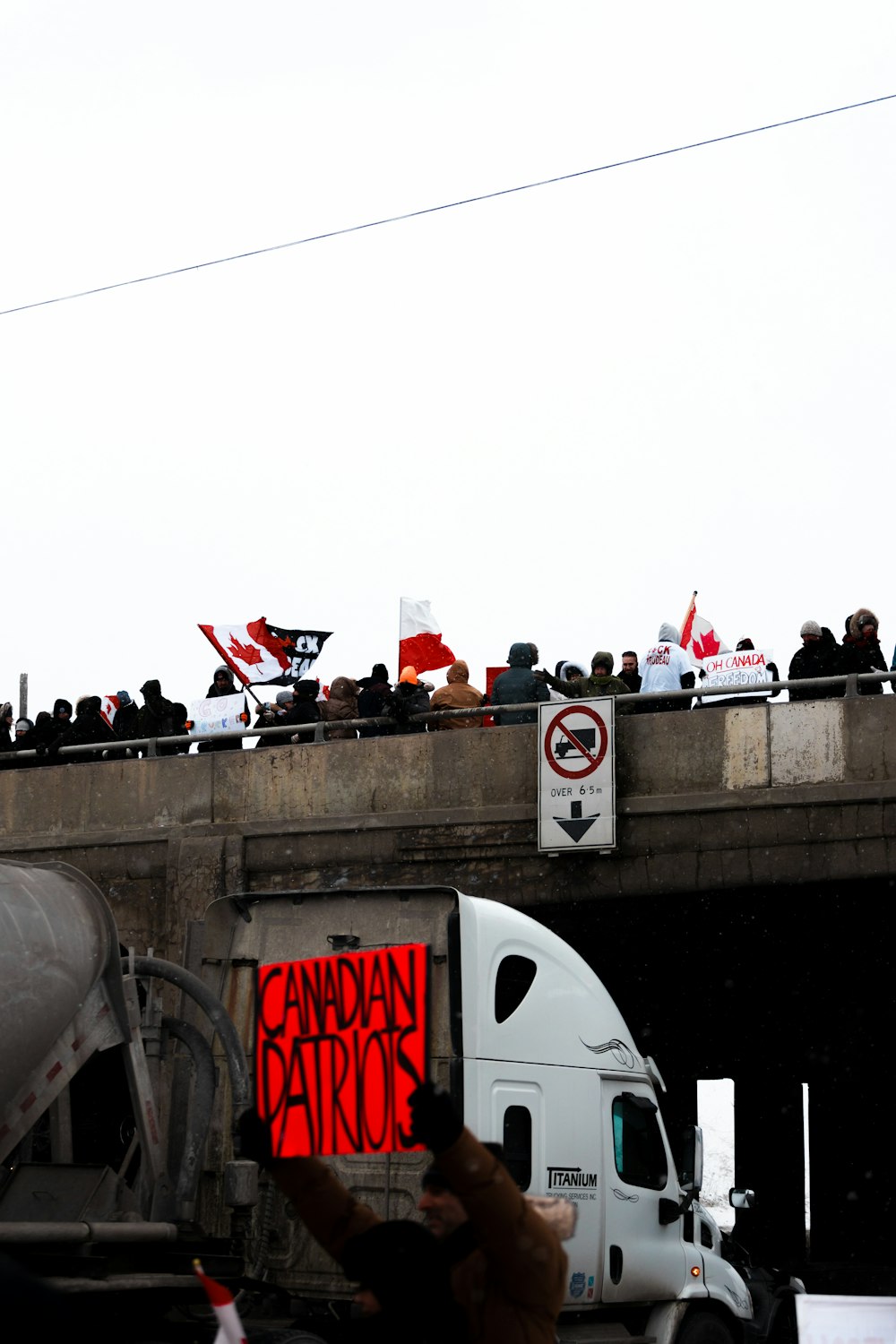 a crowd of people standing on top of a bridge