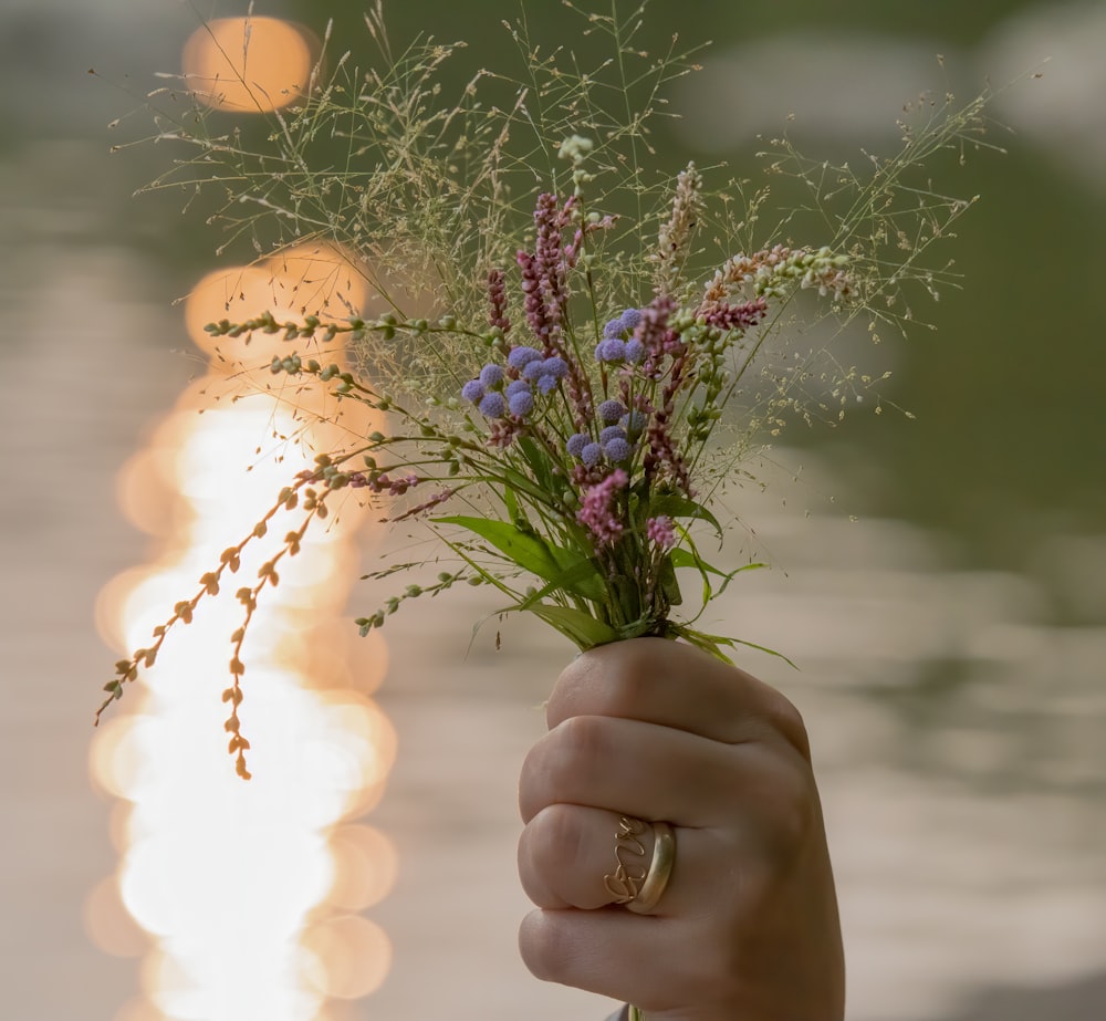 a person holding a bouquet of flowers in their hand