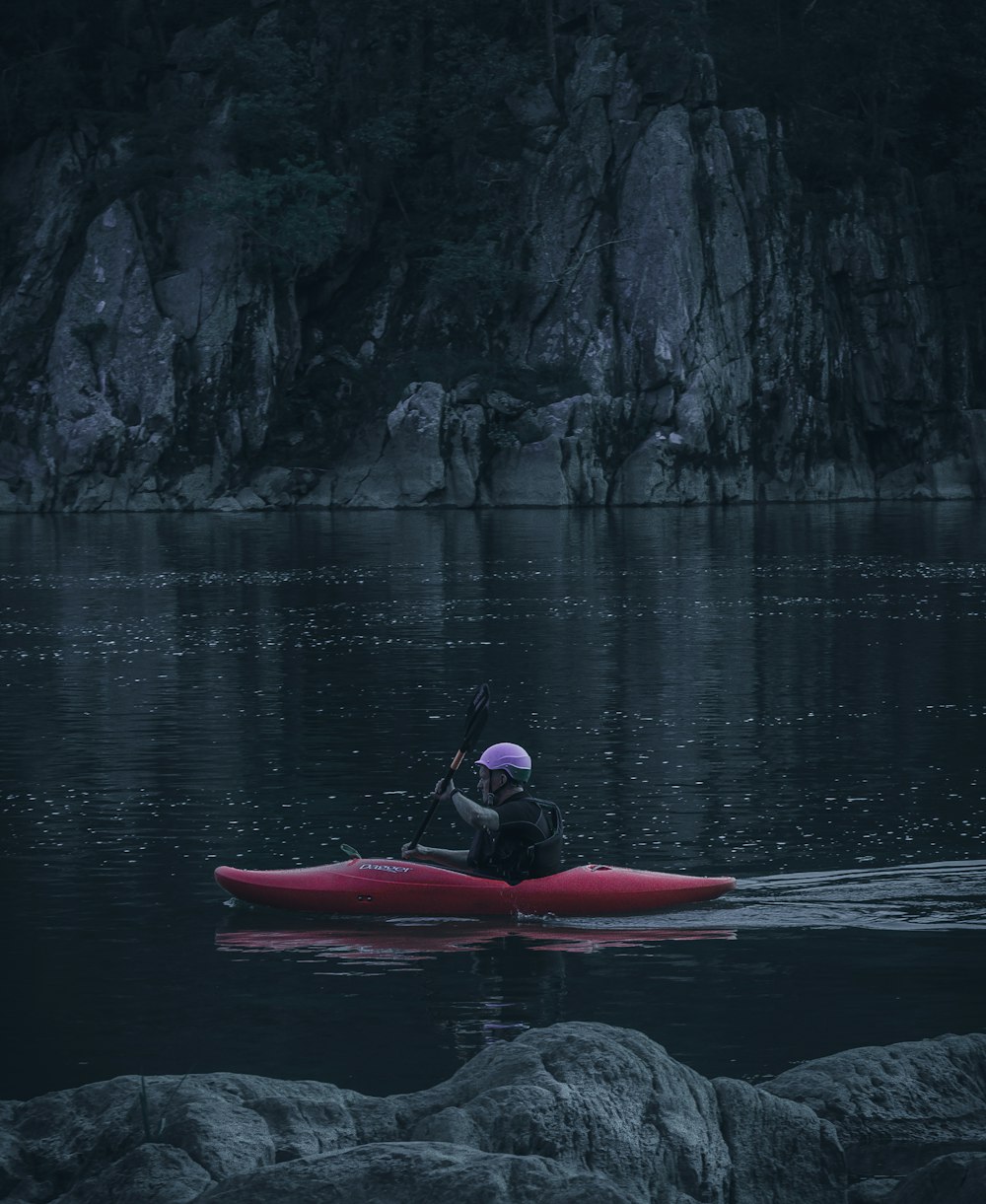 a person in a red kayak on a body of water