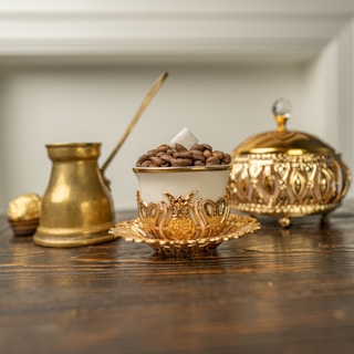 a wooden table topped with copper and brass decor accents