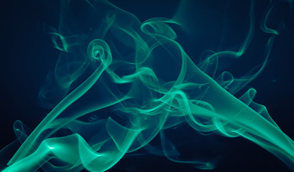 a blue and green smoke is shown against a black background