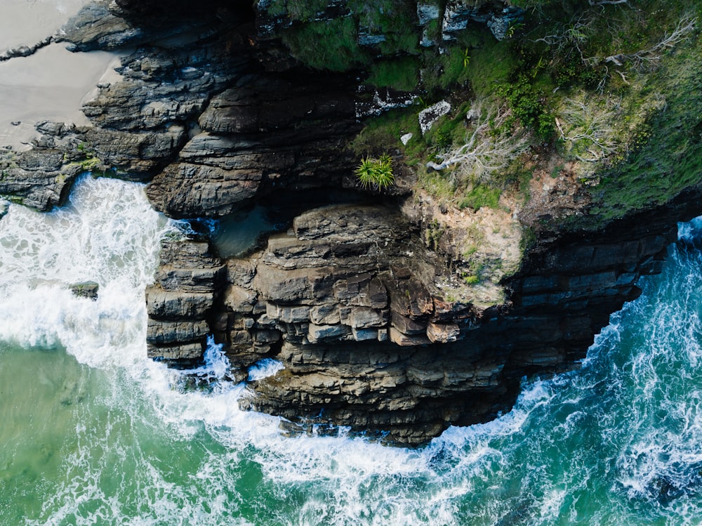 an aerial view of the ocean and rocks