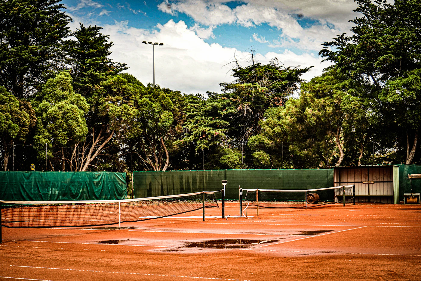 Quiet clay tennis court with restrained colors and no crowd.