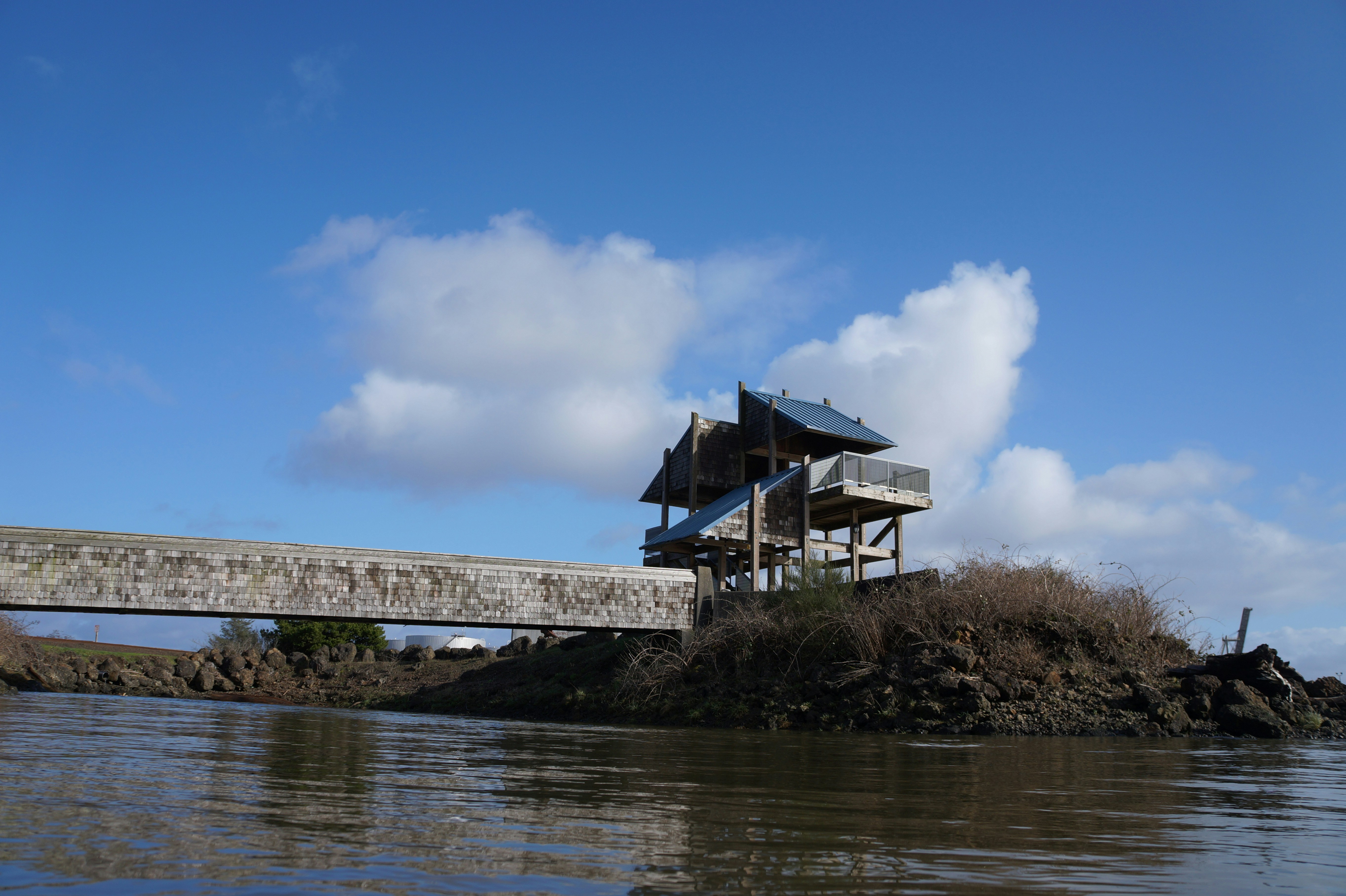 Una casa seduta sulla cima di una collina vicino a uno specchio d'acqua