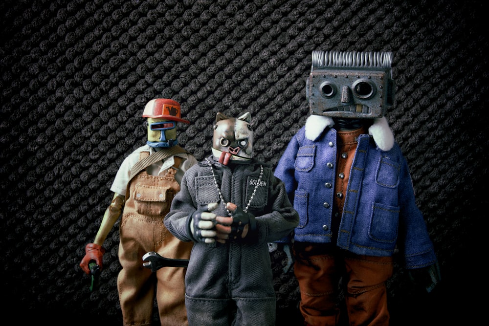 a group of three action figures standing next to each other