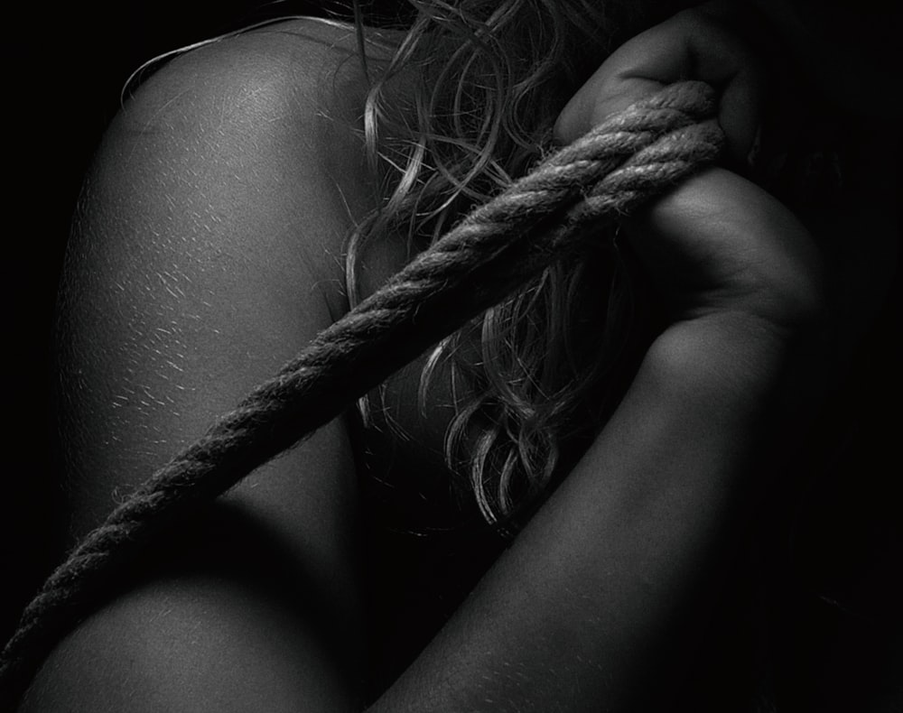 a woman tied up to a rope with her hands