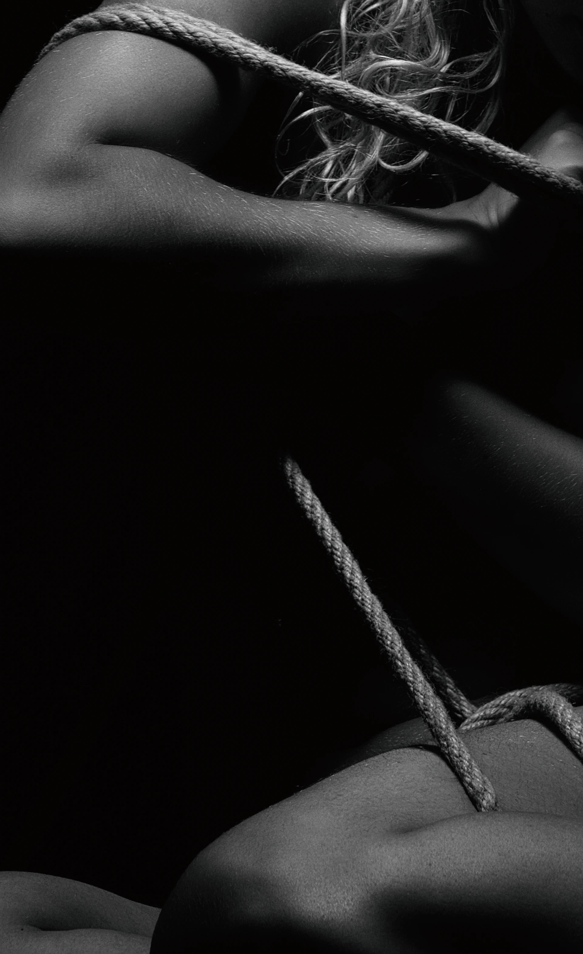 a black and white photo of a woman tied up