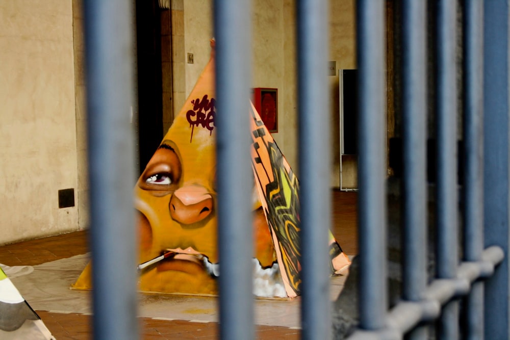 a painting of a face behind bars in a jail cell