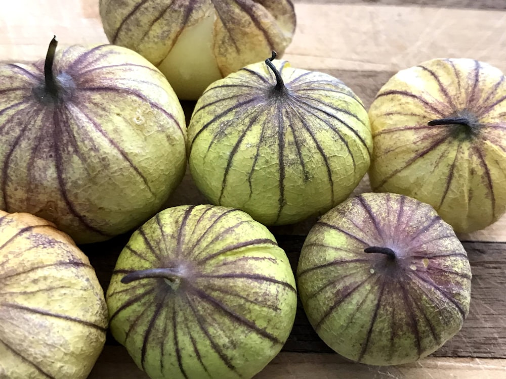 Un montón de manzanas verdes sentadas encima de una mesa de madera