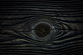 a close up of a wooden surface with a circular hole in the center