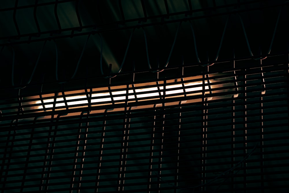 a close up of a window with blinds in the dark