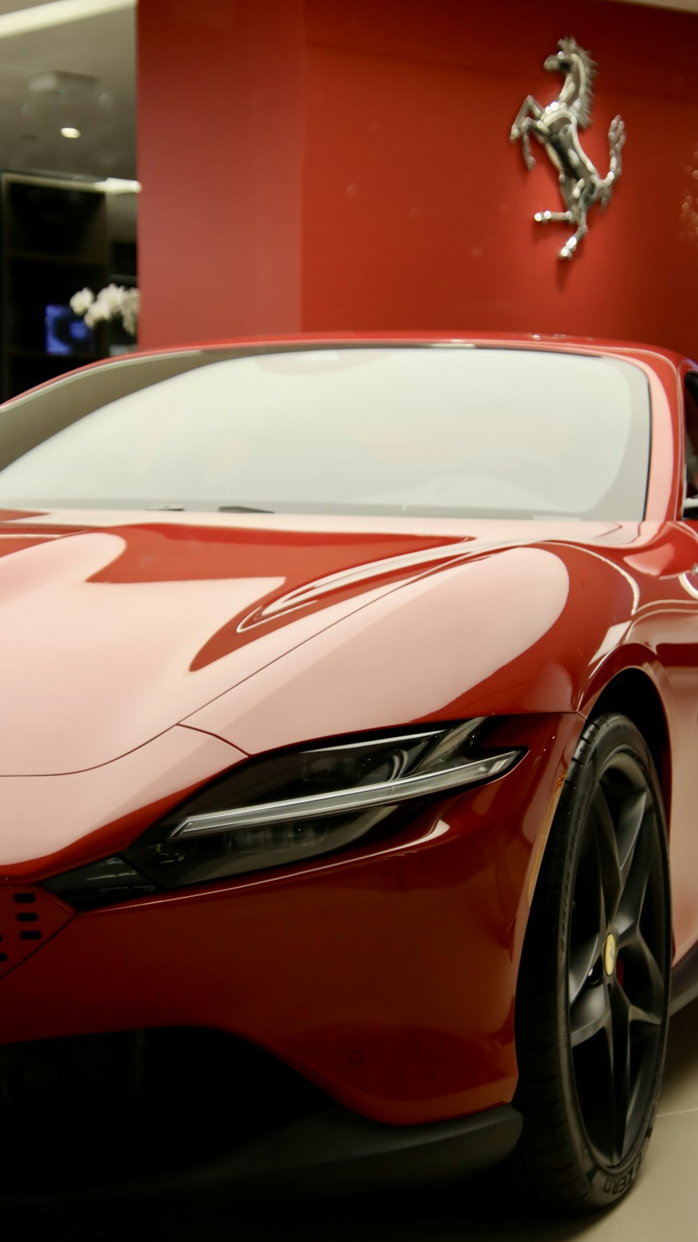 Une voiture de sport rouge garée dans une salle d’exposition