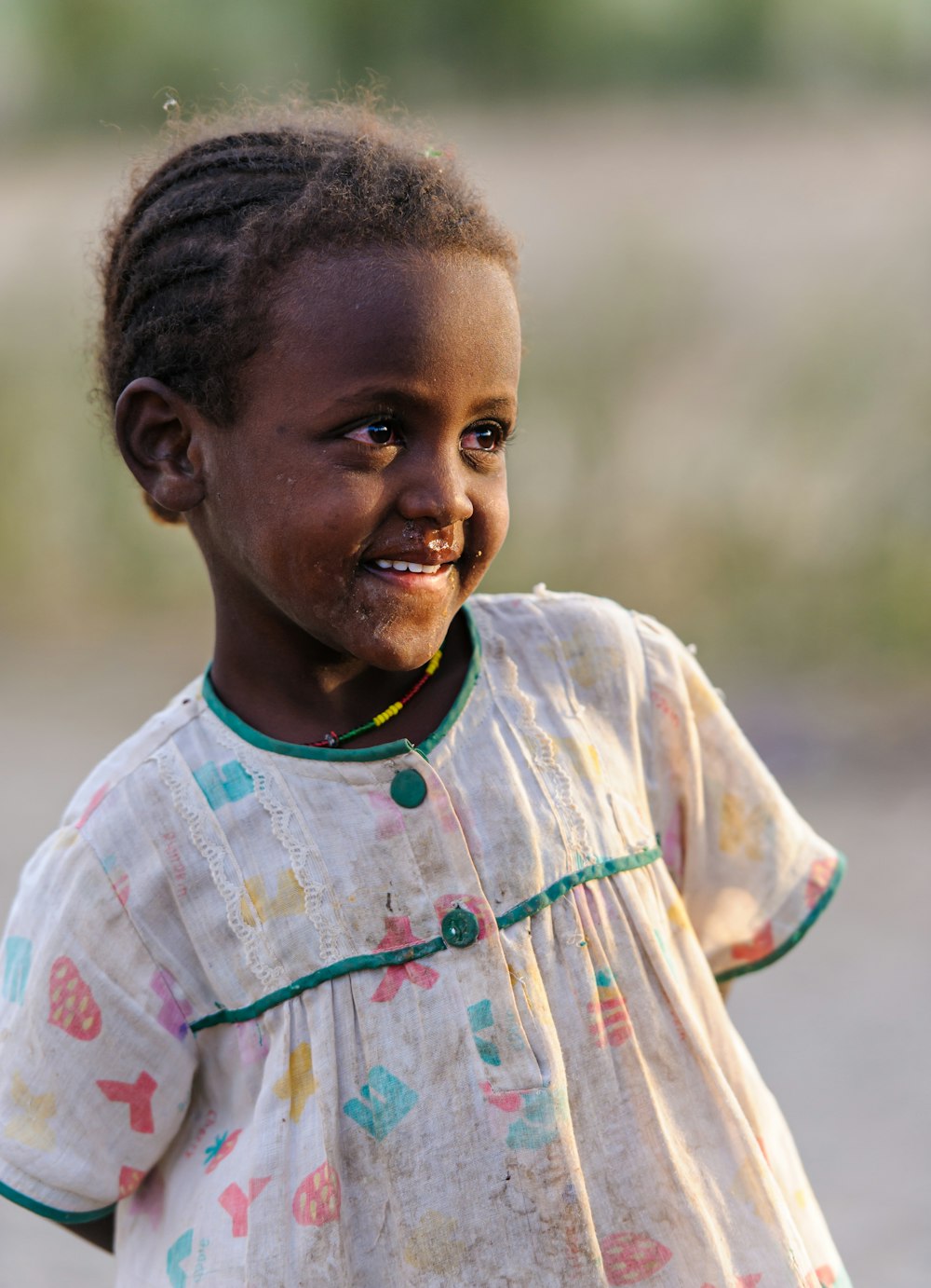 a little girl that is standing in the dirt