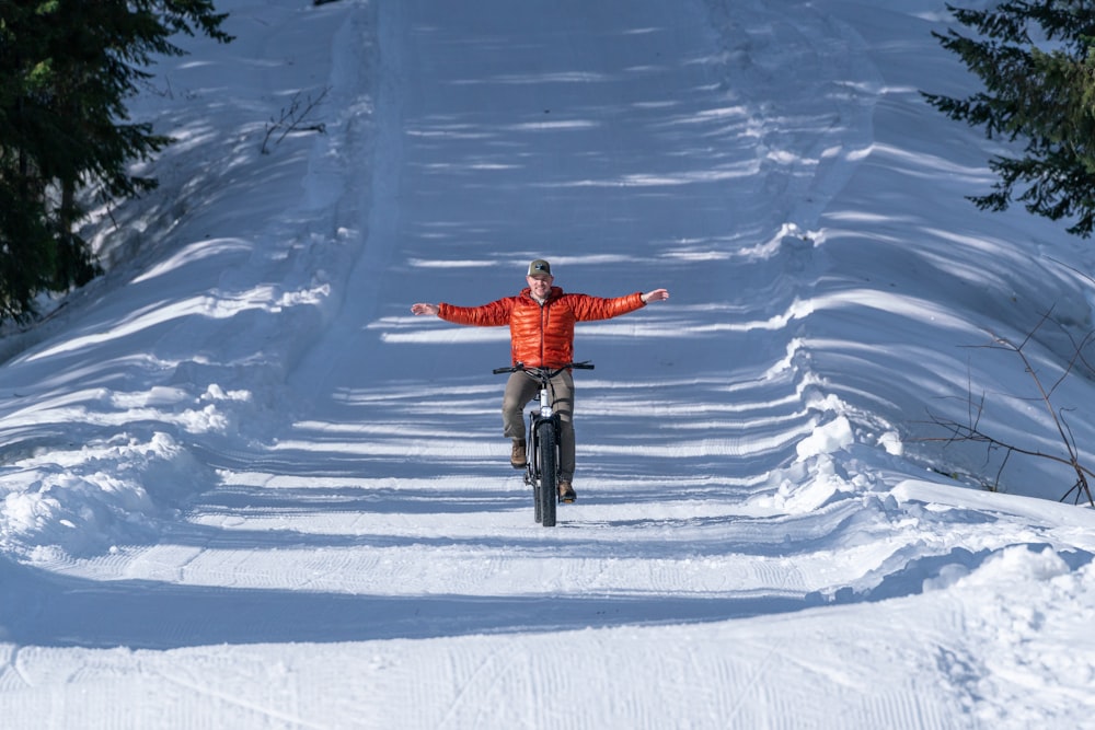 a man riding a bike down a snow covered slope