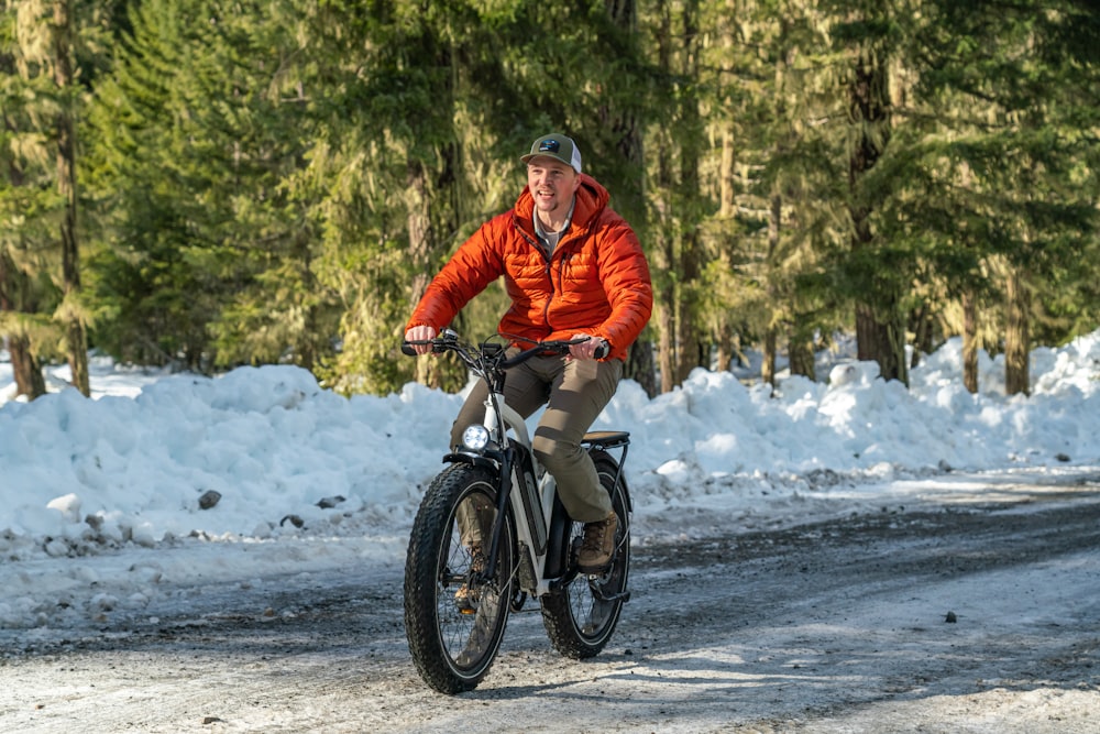 a man riding a bike down a snow covered road