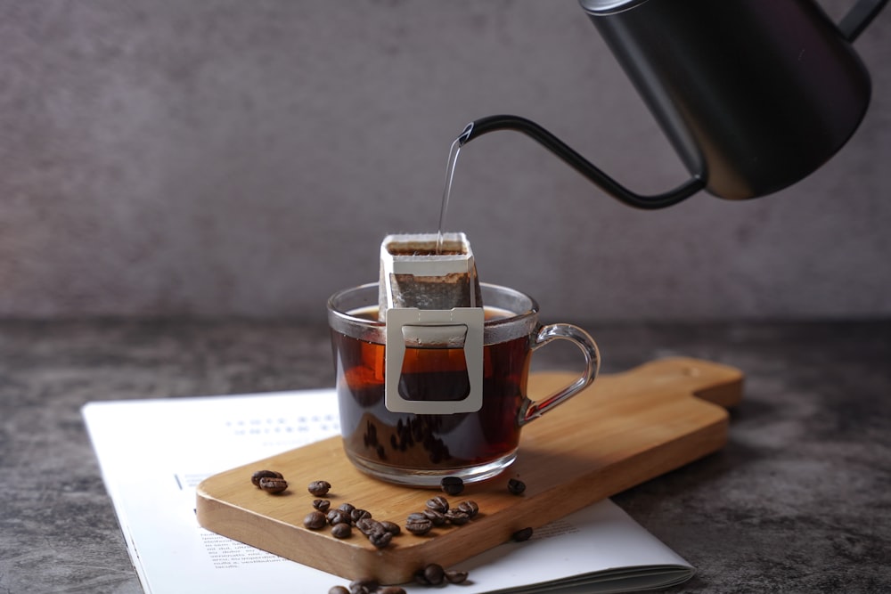 a cup of coffee being poured into a mug