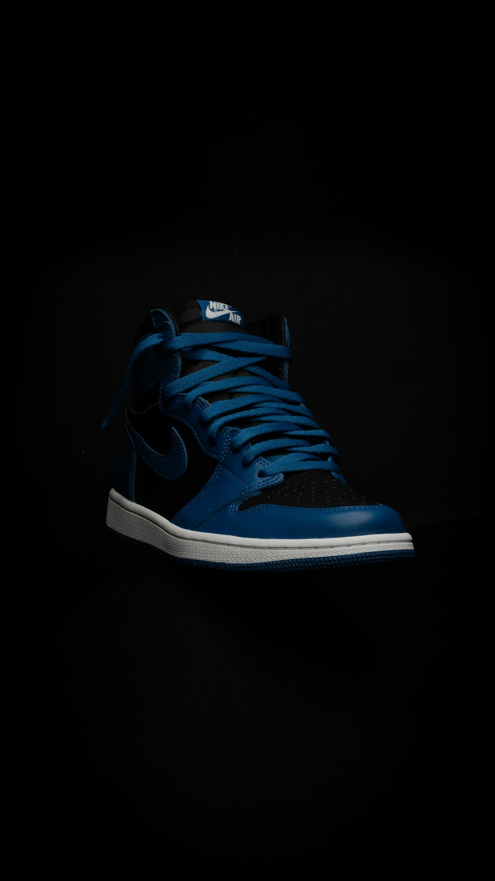 a pair of blue sneakers on a black background